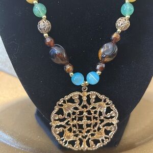 Beaded Necklace with Gold Colored Medallion 20” long; Beads Brown, Blue & Green